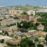 Aerial view of downtown Kenosha, Wisconsin, showcasing residential neighborhoods, historic churches, marina, and Lake Michigan shoreline in the background.