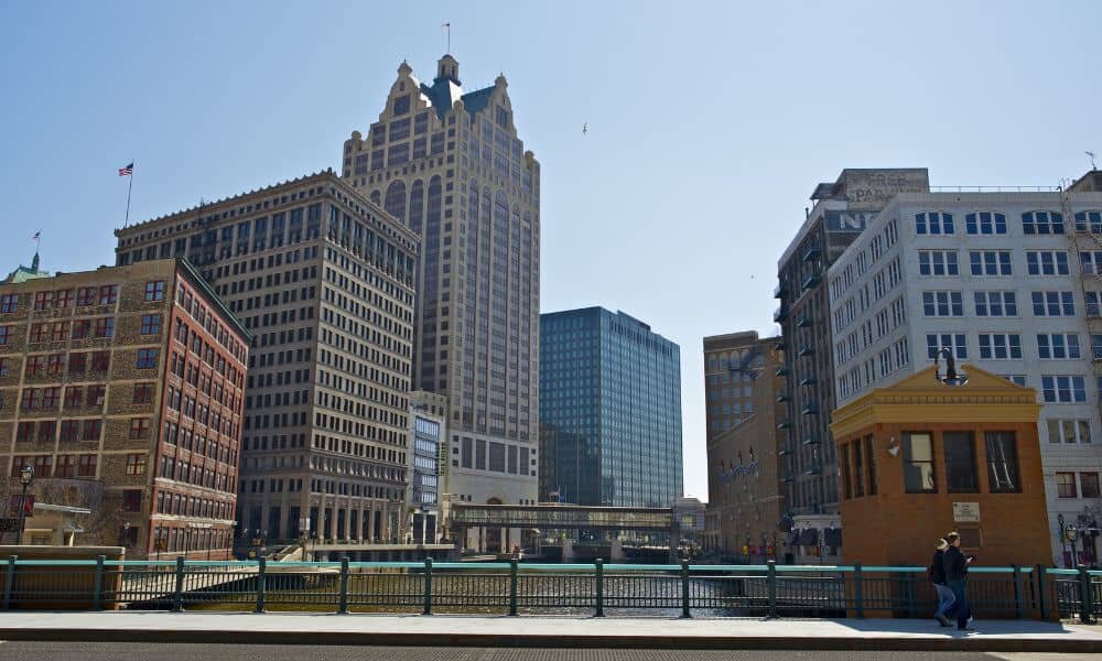 Downtown West Allis view featuring historic and modern buildings near the riverwalk, symbolizing the urban real estate market for homeowners navigating divorce and selling in West Allis.