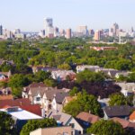 Aerial view of Brookfield residential neighborhood with tree-lined streets and downtown Milwaukee skyline in the background on a clear day.