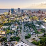 Aerial view of downtown Milwaukee, Wisconsin, showcasing the city skyline, residential neighborhoods, and Lake Michigan in the background.