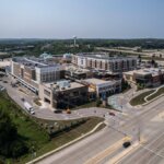 Aerial view of The Corners of Brookfield shopping and residential complex in Brookfield, Wisconsin, surrounded by major roads and greenery.