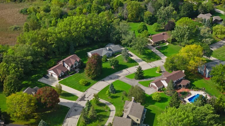 Aerial view of a quiet suburban neighborhood in Brookfield with curved streets, single-family homes, green lawns, and surrounding trees.