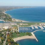 Aerial view of Kenosha, WI, showing the harbor, beach, and Lake Michigan shoreline on a clear day.
