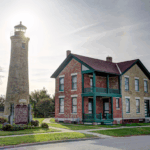 Historic lighthouse and keeper's house in Kenosha, Wisconsin, under a bright sky.