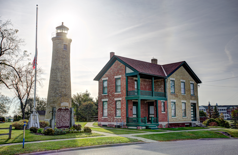 Historic lighthouse and keeper's house in Kenosha, Wisconsin, under a bright sky.