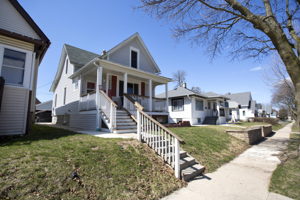 Residential street in West Allis featuring a row of well-kept single-family homes with porches on a sunny day.