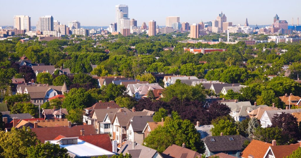 Aerial view of residential homes in Brookfield, Wisconsin, with the Milwaukee skyline in the background on a clear day.