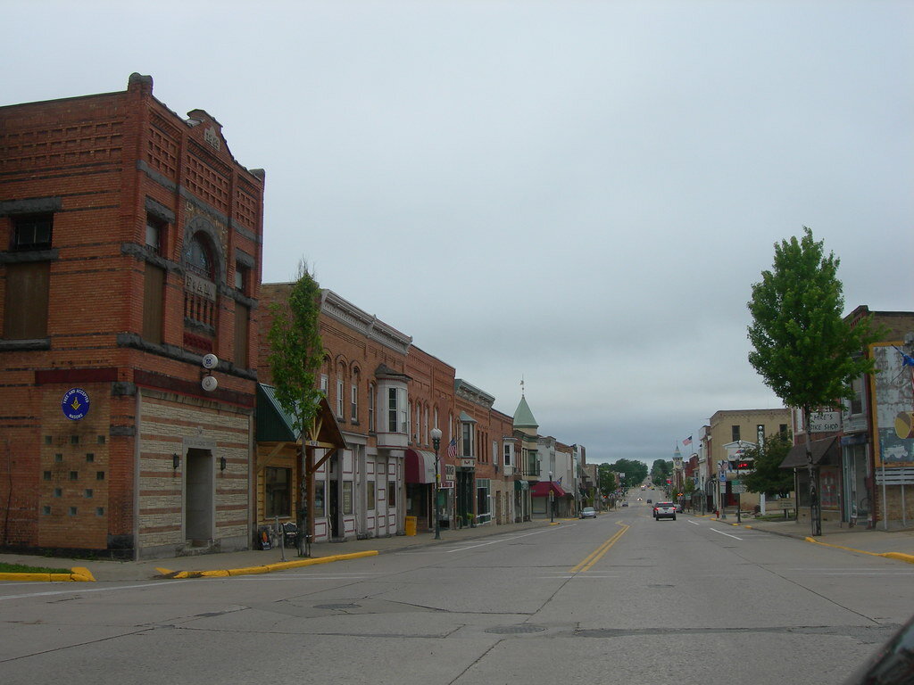 Downtown street in New Berlin with historic brick buildings and shops on a cloudy day.