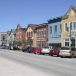 Colorful storefronts and parked cars along a small-town street in Waukesha.