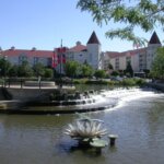 Scenic riverwalk in Waukesha, Wisconsin, with cascading water feature and historic buildings in the background.