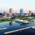 Aerial view of downtown Milwaukee skyline with high-rise buildings and Lake Michigan waterfront.