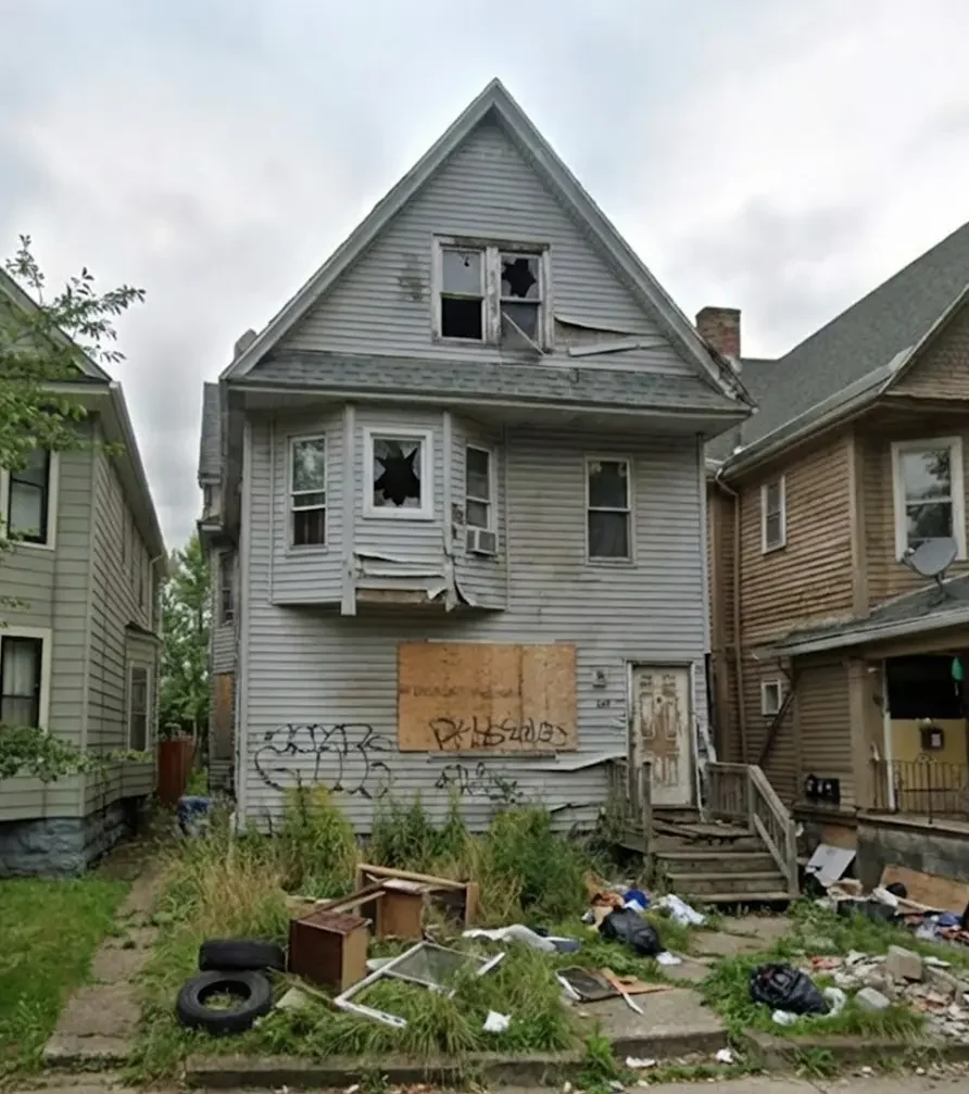 Exterior of a distressed Buffalo house with debris and cleanout issues