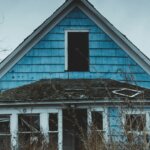 Weathered vacant house with overgrown yard, similar to vacant houses in Xenia, Ohio