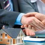Handshake over a house model and keys after a cash home sale in Springfield, Ohio