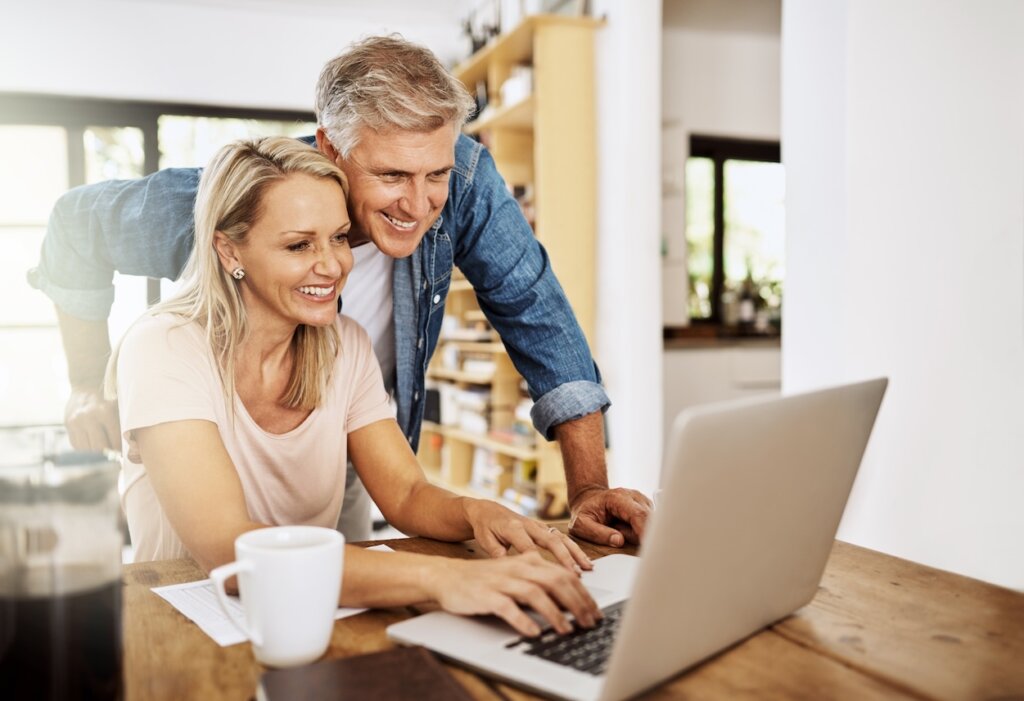 Smiling mid 40s couple looking at a computer