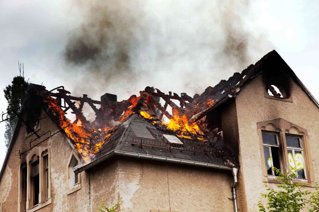 a house that is on fire and the roof has caved in