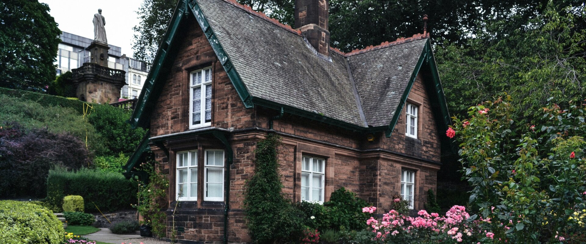 a brick house sitting in a nice garden