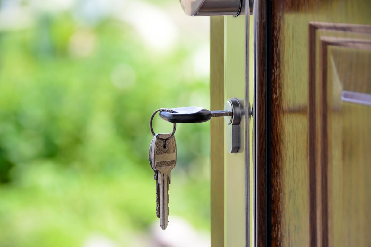 a key in the lock of a house that is for sale