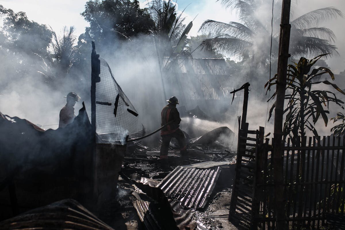 firefighters in a house that has burned down