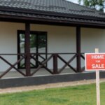 a house with a for sale sign in the front yard