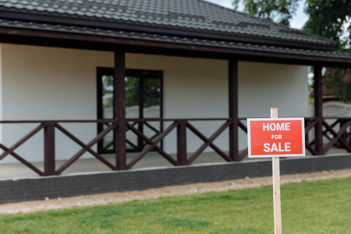 a house with a for sale sign in the front yard