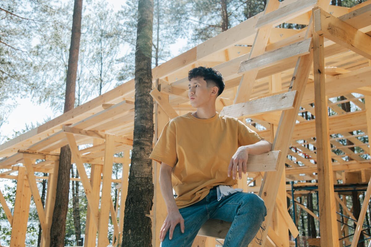 a man resting on a building that is being built