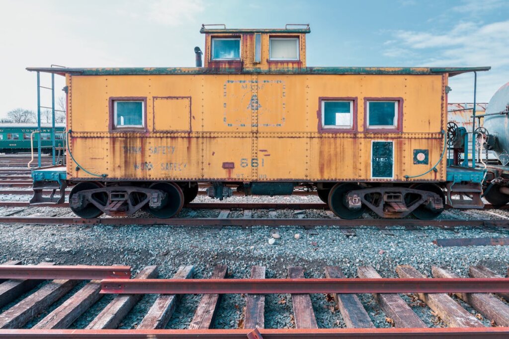 A yellow caboose on a train track