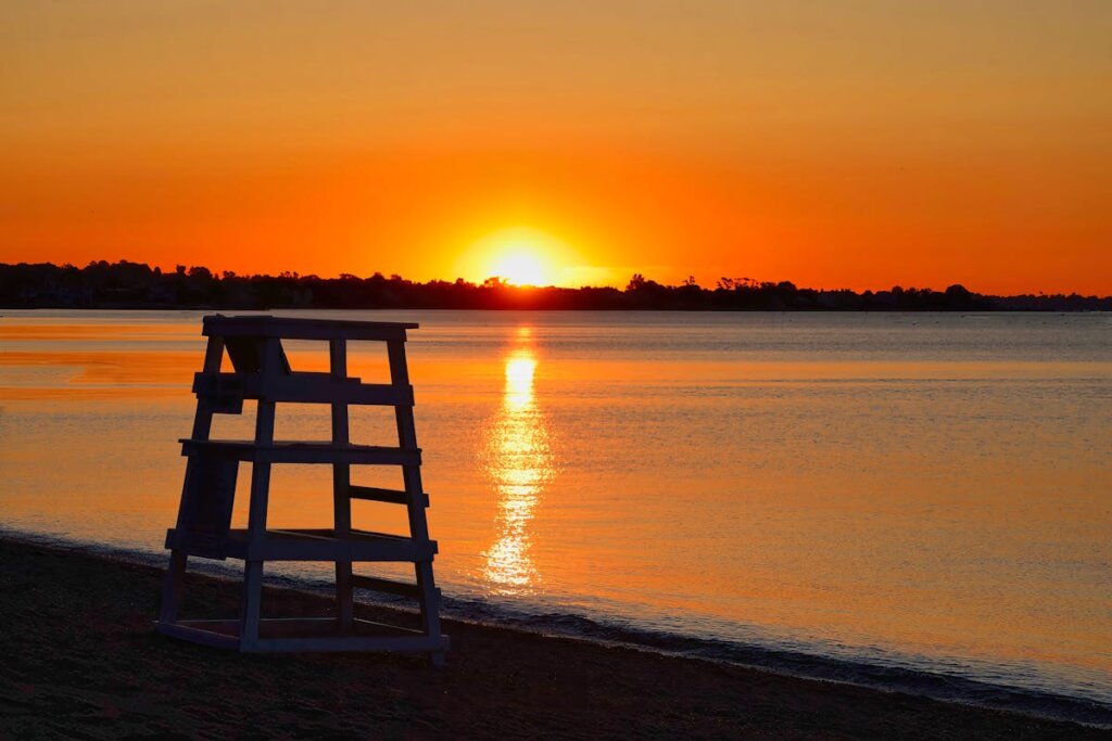 A life guard chair on a beach during sunset