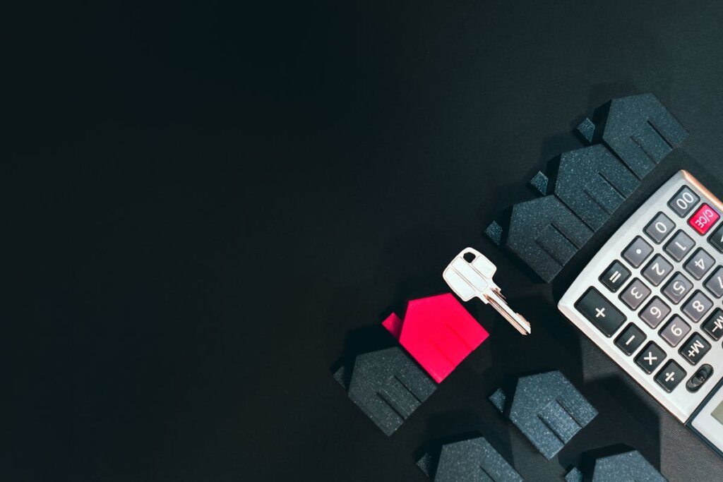 A key next to a bunch of small houses and a calculator
