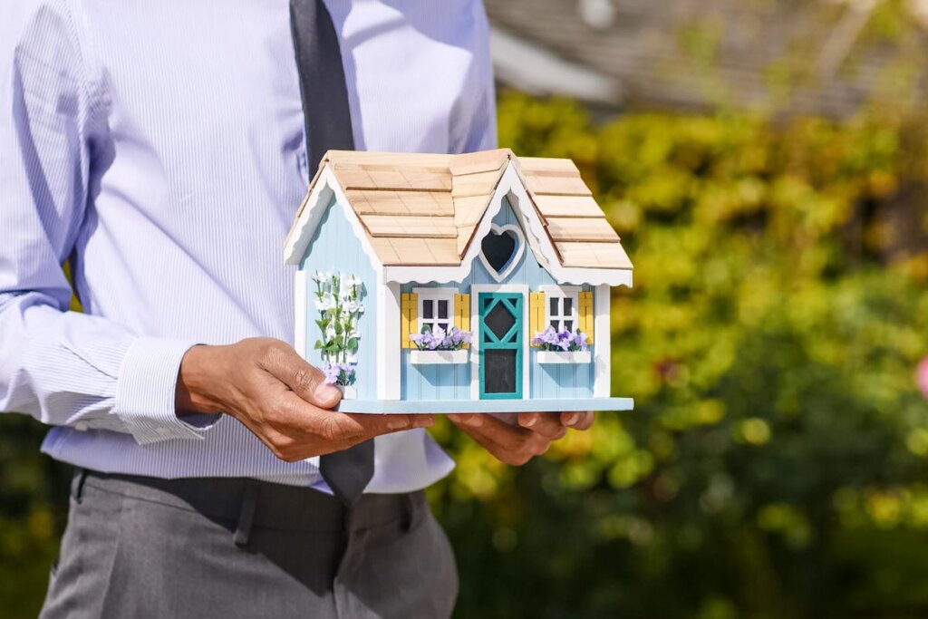 A man holding a small wooden house