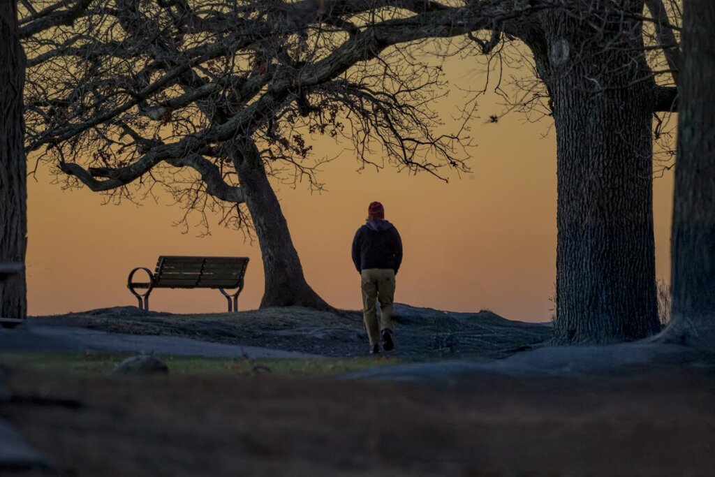 A person walking with a sunset in the backround
