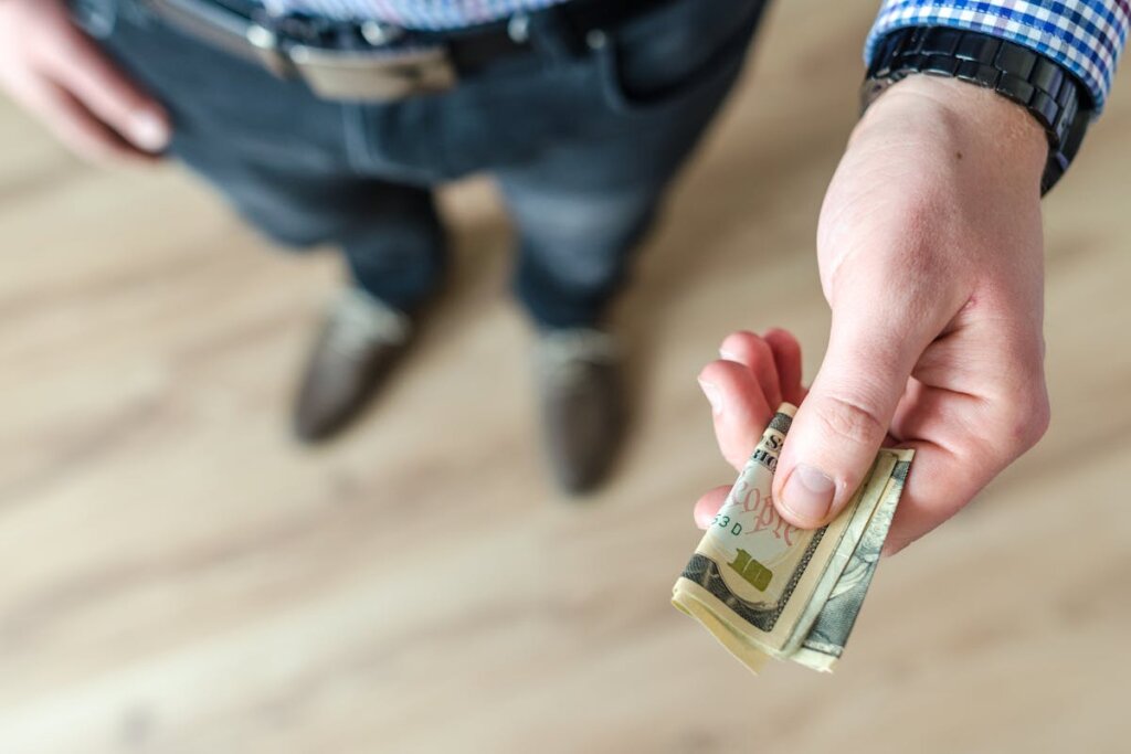 A man handing over some cash to another person