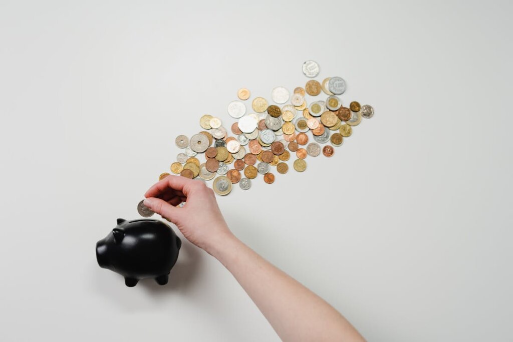 A piggy bank with coins spread out above it