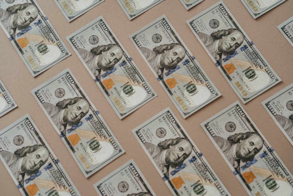 A bunch of 100 dollar bills all laid out evenly on a table