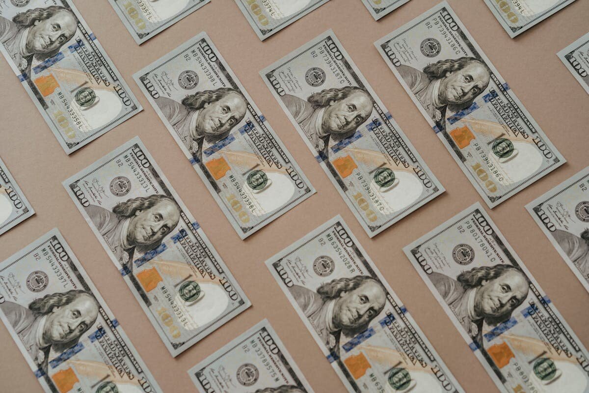 A bunch of 100 dollar bills all laid out evenly on a table