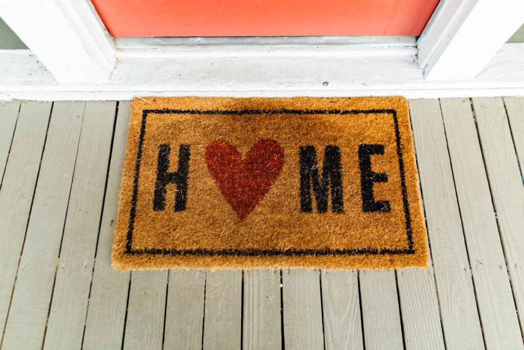 A rug outside of a house door that says home on it