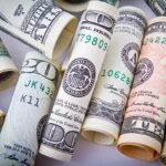 A bunch of American cash all rolled up and in a pile
