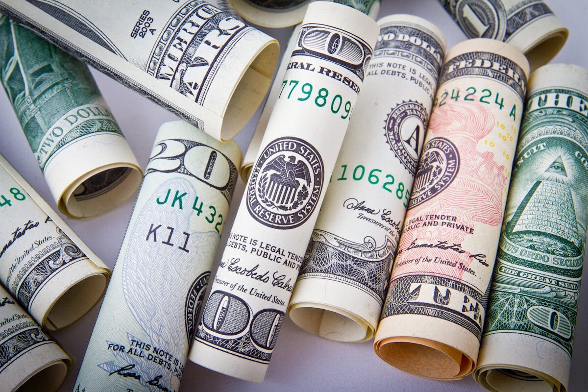 A bunch of American cash all rolled up and in a pile
