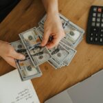 A person counting money on a table