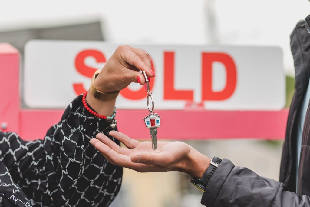 A person handing a key over to another person who purchased the house