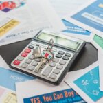A bunch of papers with a calculator on top