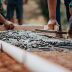 A bunch of people creating a foundation for a house