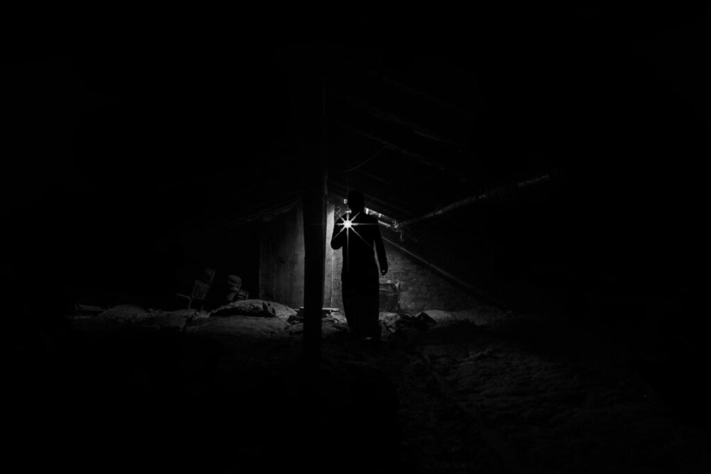 A person in the basement with a flashlight