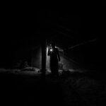 A person in the basement with a flashlight