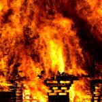A house that is on fire and absolutely destroyed