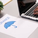 A person next to a paper that has insurance on it