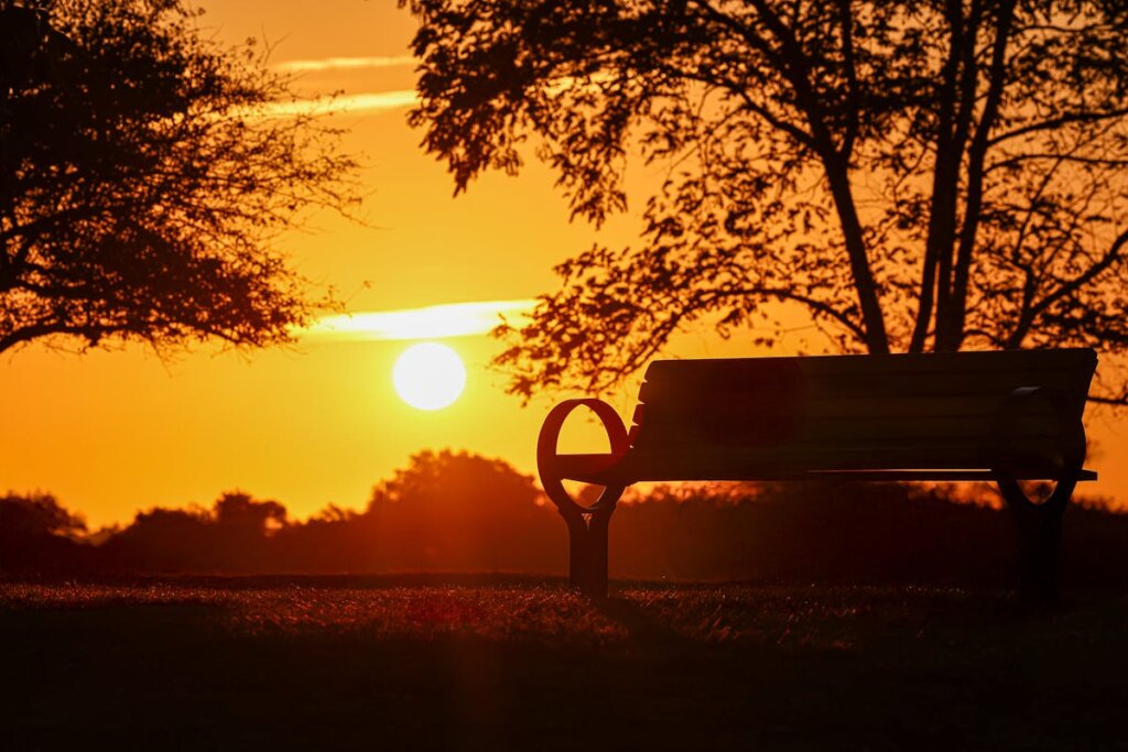 A park bench in front of a sunset