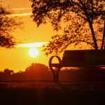 A park bench in front of a sunset