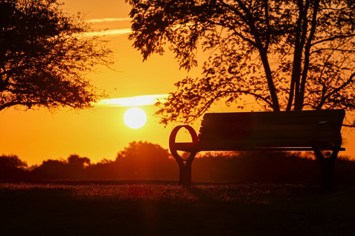 A park bench in front of a sunset
