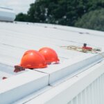 A bunch of hard hats on a roof with a rope next to it